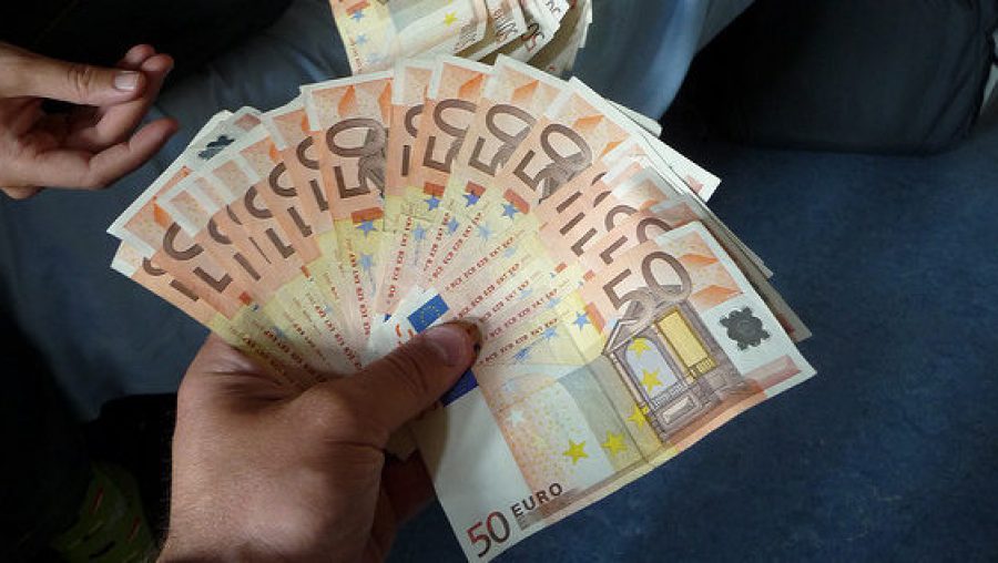 Main tenant une liasse de billets de 50 euros