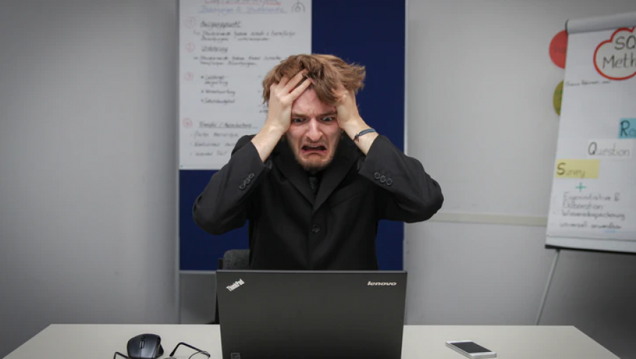 une personne s'arrache les cheveux devant un ordinateur