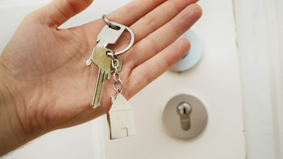 personne tenant des clés de maison en main
